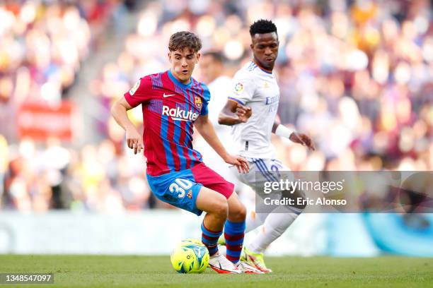 Gavi of FC Barcelona battles for possession with Vinicius Junior of Real Madrid during the LaLiga Santander match between FC Barcelona and Real...