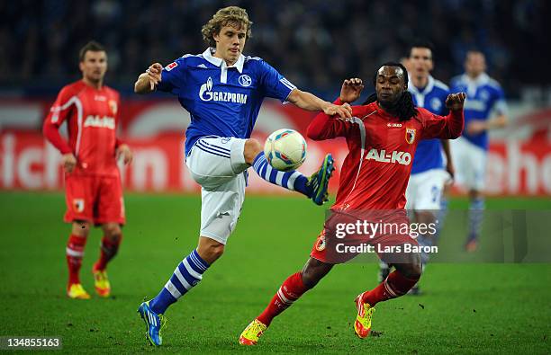 Teemu Pukki of Schalke is challenged by Lorenzo Davids of Augsburg during the Bundesliga match between FC Schalke 04 and FC Augsburg at Veltins Arena...