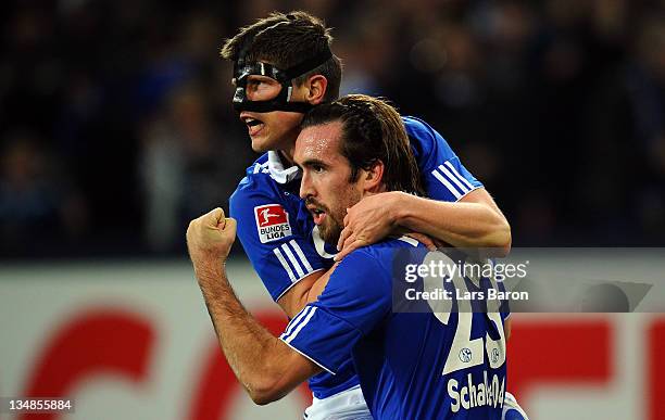 Christian Fuchs of Schalke celebrates with team mate Klaas Jan Huntelaar after scoring his teams second goal during the Bundesliga match between FC...