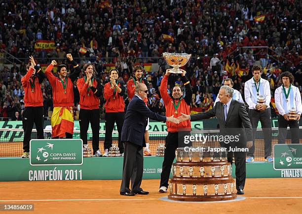 Team captain Albert Costa celebrates with the trophy after receiving it from King Juan Carlos of Spain and the President of the Spanish tennis...