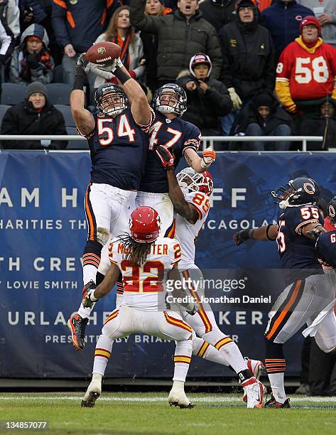 Brian Urlacher and Chris Conte of the Chicago Bears leap to knock down a "Hail Mary" pass as Dexter McCluster of the Kansas City Chiefs waits to...