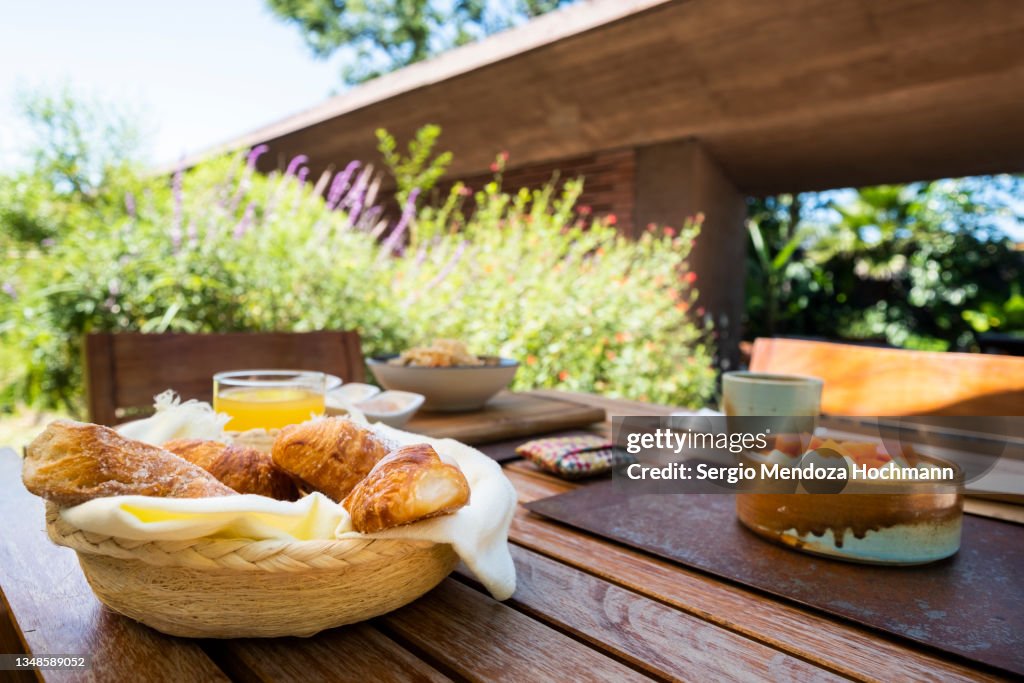 A delicious Mexican breakfast of fresh fruit, a bowl with papaya and pineapple freshly cut, chilaquiles with shredded chicken and hot salsa sauce, sweet pastries, Mexican food - Tepoztlan, Mexico