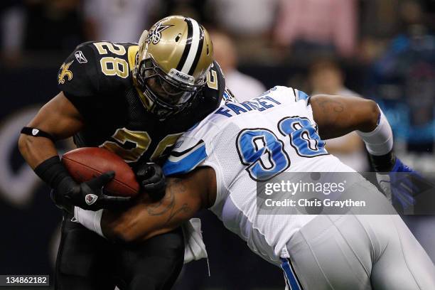 Running back Mark Ingram of the New Orleans Saints is hit by defensive tackle Nick Fairley of the Detroit Lions in the first quarter at Mercedes-Benz...