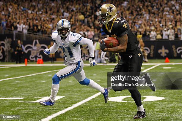 Wide receiver Robert Meachem of the New Orleans Saints runs past cornerback Eric Wright of the Detroit Lions after a catch for a 67 yard touchdown at...