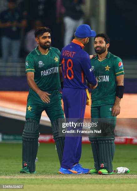 Mohammad Rizwan and Babar Azam of Pakistan interact with Virat Kohli of India following the ICC Men's T20 World Cup match between India and Pakistan...