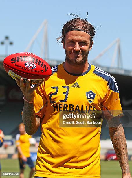David Beckham of the Galaxy poses with an Australian Rules AFL football during an LA Galaxy training session at Visy Park on December 5, 2011 in...