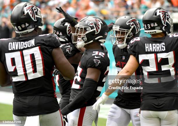 Jaylinn Hawkins of the Atlanta Falcons celebrates with teammates after making and interception during the second quarter in the game against the...