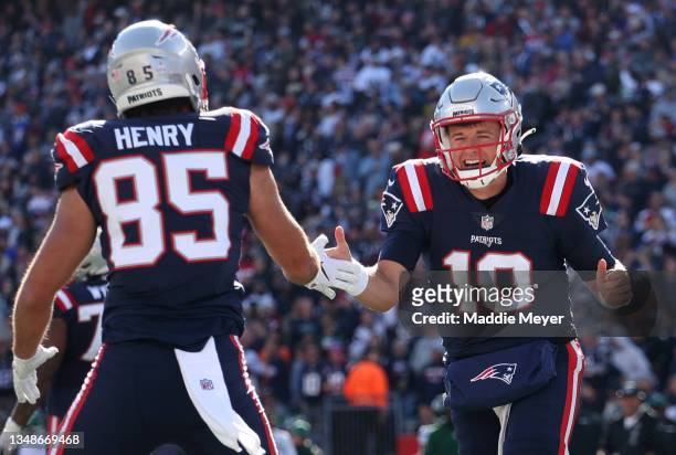 Mac Jones of the New England Patriots celebrates with Hunter Henry after a touchdown during the second quarter in the game against the New York Jets...
