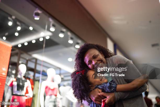 mother and daughter hugging each other at the mall - shopping mall stock pictures, royalty-free photos & images