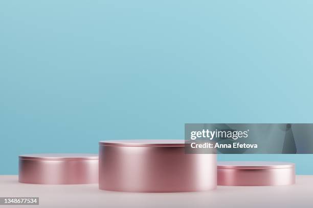 three cylindrical pink metal podiums on blue background. perfect platform for showing your products. three dimensional illustration - championship round three stockfoto's en -beelden