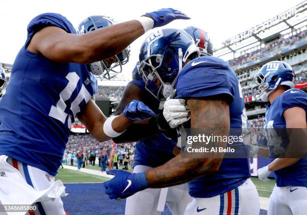 Devontae Booker of the New York Giants celebrates a touchdown with teammates during the second half in the game against the Carolina Panthers at...