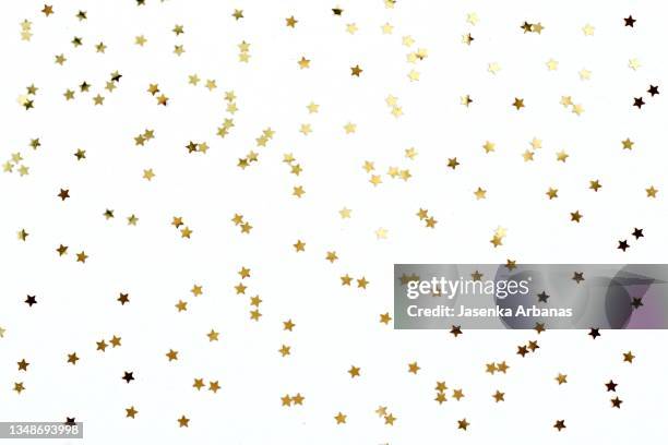 golden confetti on white background - holiday sparkle stock pictures, royalty-free photos & images