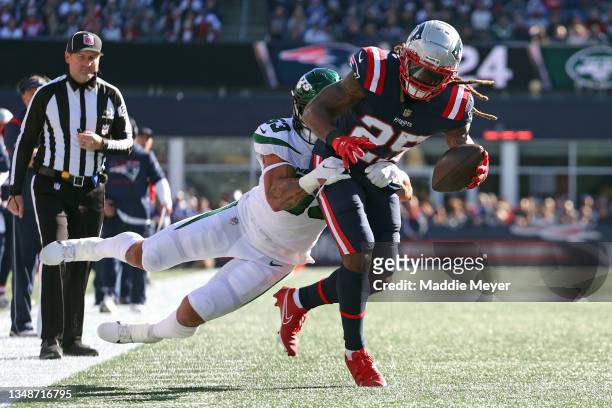 Brandon Bolden of the New England Patriots makes a catch ahead ov Blake Cashman of the New York Jets at Gillette Stadium on October 24, 2021 in...