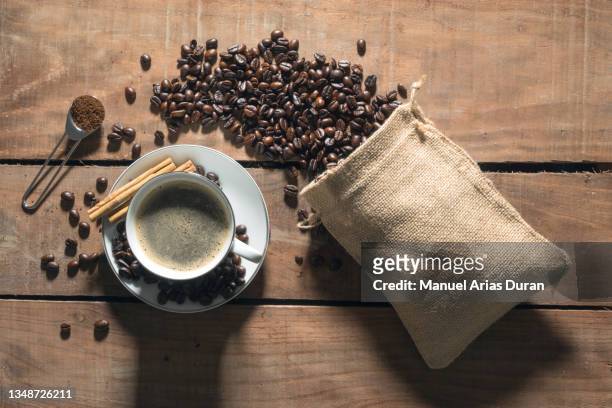 top view of a coffee cup next to a bag of coffee beans. - coffee package stock-fotos und bilder