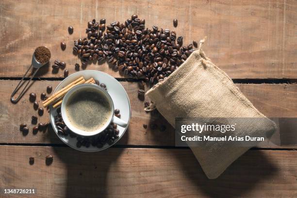top view of a coffee cup next to a bag of coffee beans. - decaffeinated stock pictures, royalty-free photos & images