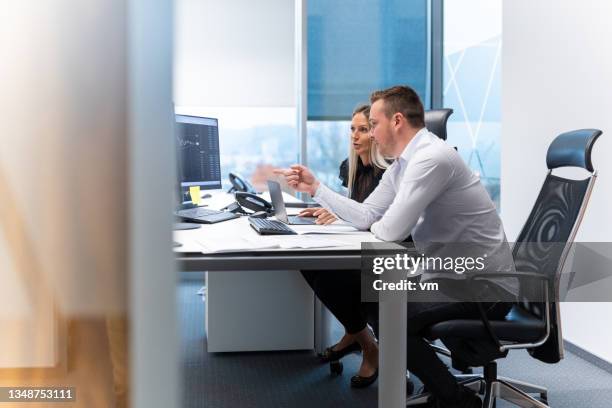 femme d’affaires et homme d’affaires caucasien en coworking à un bureau - financial analyst photos et images de collection