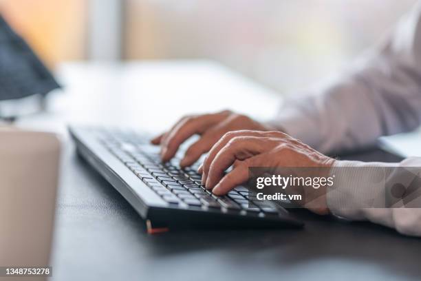 primer plano de manos masculinas escribiendo en un teclado en una oficina - arabic keyboard fotografías e imágenes de stock