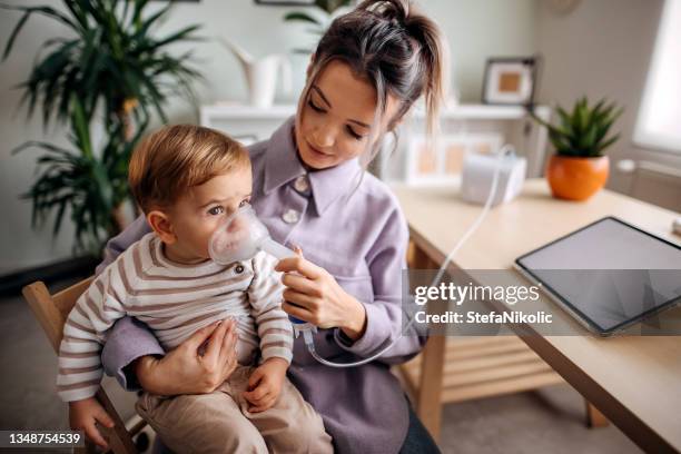 kleiner junge macht inhalation zu hause - mukoviszidose stock-fotos und bilder