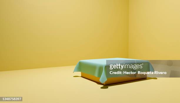 3d render of green cloth on top of orange table with yellow background, copy space - orange silk background stock pictures, royalty-free photos & images