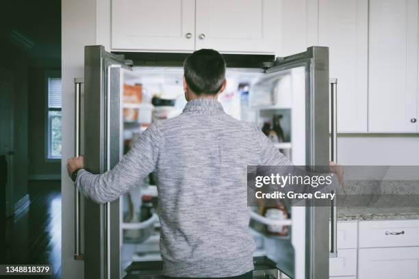 man searches refrigerator for food - us open 個照片及圖片檔