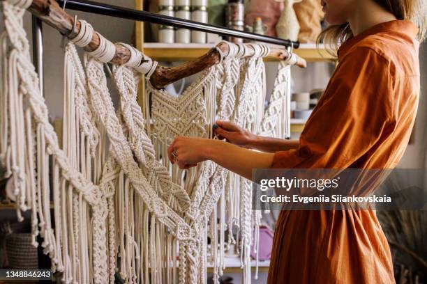 young woman making a macrame work inside her house - macrame stock pictures, royalty-free photos & images