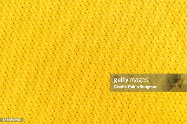yellow color sports clothing fabric football shirt jersey texture and textile background. - yellow shirt fotografías e imágenes de stock