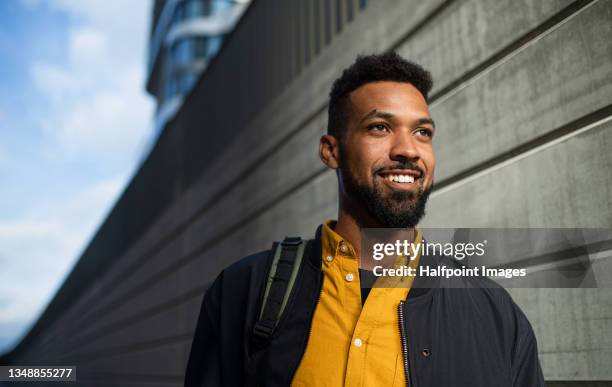 portrait of happy man commuter walking on the way to work, sustainable lifestyle. - beard men street foto e immagini stock