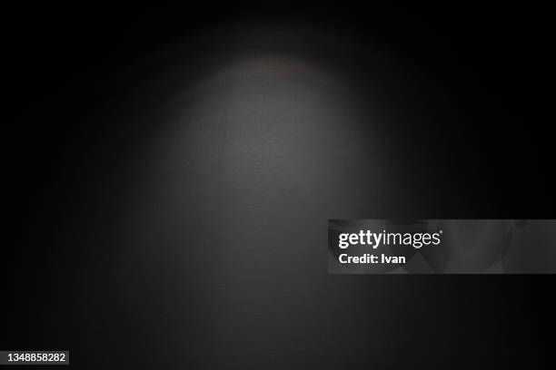 illuminated spotlight studio background - zwarte achtergrond stockfoto's en -beelden