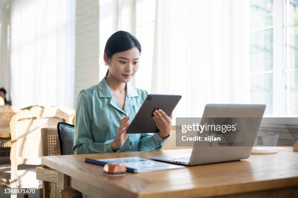young businesswomen working with digital tablet - japanese ethnicity working woman stock pictures, royalty-free photos & images