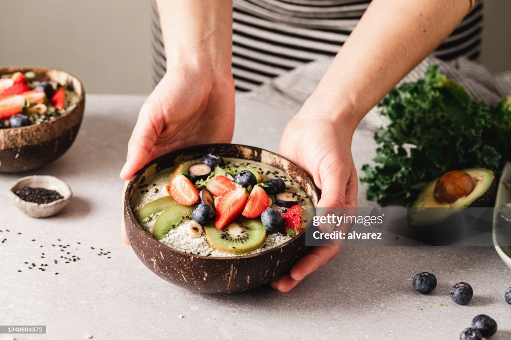 Woman making healthy smoothie bowl
