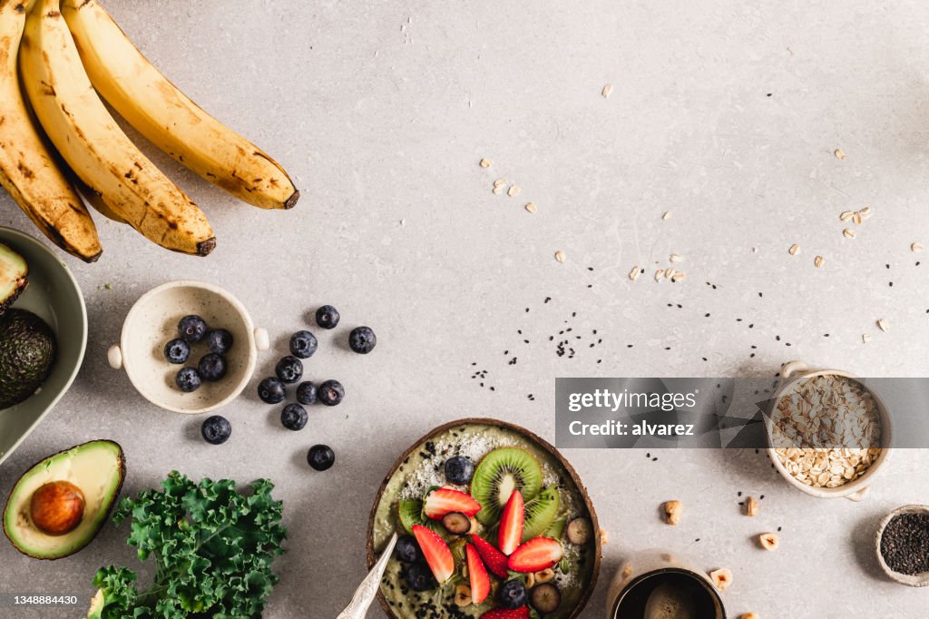 Bol de smoothie sain avec des ingrédients sur le comptoir de la cuisine
