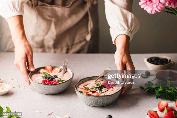 キッチンでイチゴスムージーボウルを準備する女性 - blended drink ストックフォトと画像