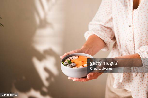 close-up of a woman holding a healthy smoothie bowl - papaya stock pictures, royalty-free photos & images