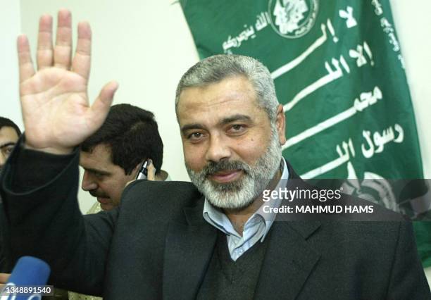 Senior Hamas leader and top candidate for the Palestinian parliamentary elections, Ismail Haniya, waves during a press conference held at his house...