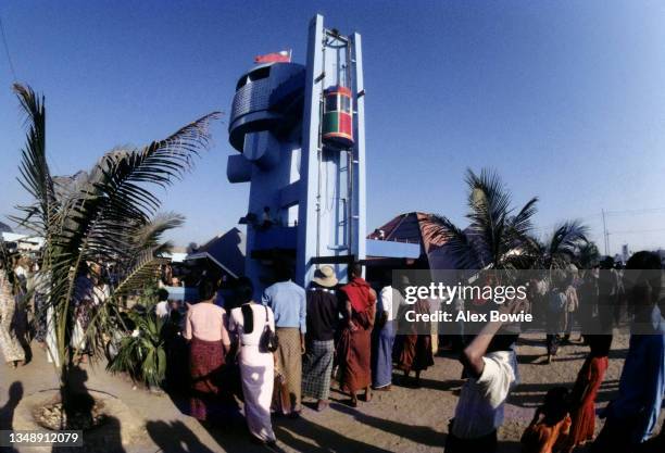 The Burmese flag flies high above visitors waiting to enter an exhibition pavilion during celebrations honouring the 36th anniversary of Burmese...