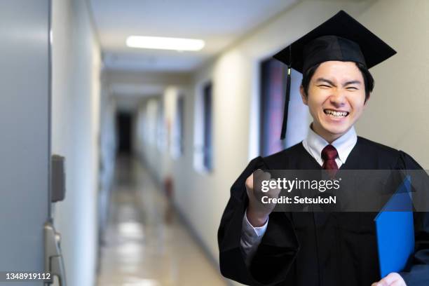 retrato de estudante do sexo masculino no dia da formatura da universidade - cerrando os dentes - fotografias e filmes do acervo