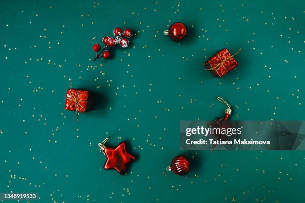 christmas and new year flat lay. red knick knack on green background. - christmas bauble 個照片及圖片檔