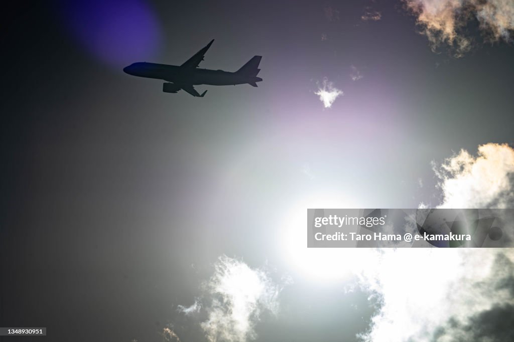 The airplane flying in the sunset sky over Fukuoka city of Japan