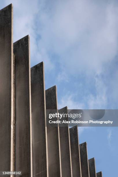 brutalist concrete pilaster shafts on a building facade shot against blue sky - brutalist building photos et images de collection