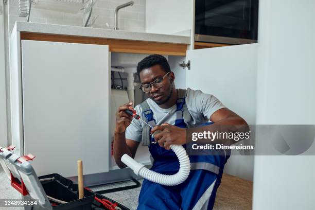 black male plumber at work - plumber stockfoto's en -beelden