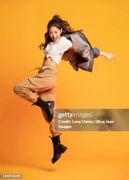 studio shot of fashionable young woman dancing - asian woman beauty shot photos et images de collection