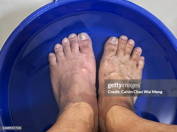 adult feet soaking in water bucket - asian foot massage stock pictures, royalty-free photos & images