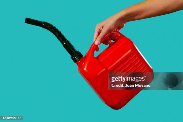 is about to pour gasoline from a red petrol can - pitorro fotografías e imágenes de stock