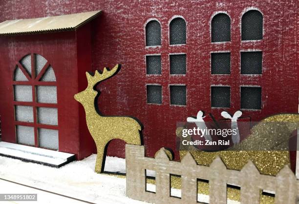 christmas decorative building with reindeer and sleigh in foreground - christmas village silhouette stock pictures, royalty-free photos & images