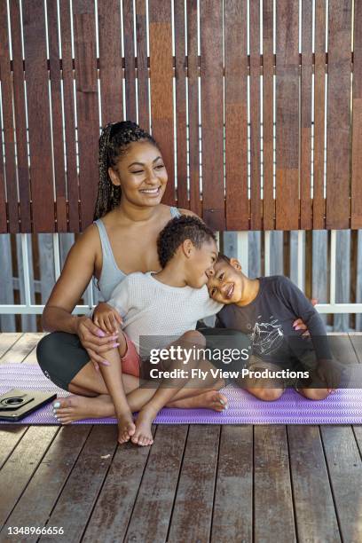 young mom exercising with sons on patio - the standard stock pictures, royalty-free photos & images