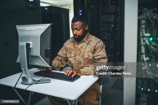 photo d’un technicien informatique masculin dans une salle de serveurs et utilisant un ordinateur portable - armée de terre photos et images de collection