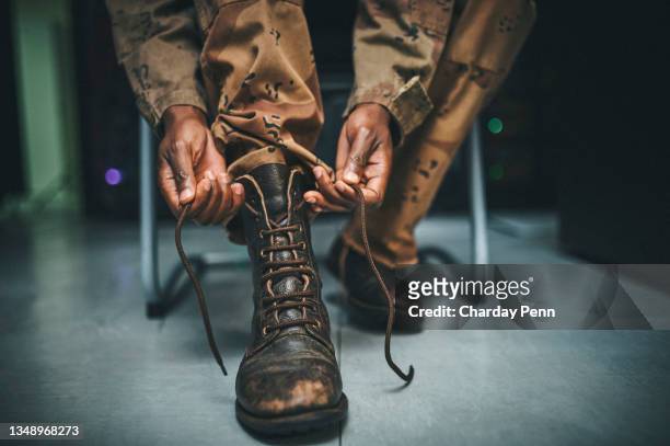 aufnahme eines soldaten, der seine stiefelschnürsenkel in den schlafsälen einer militärakademie anband - armed forces stock-fotos und bilder
