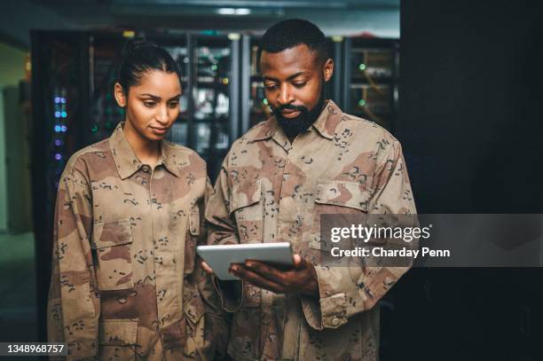 shot of a two it technicians working in a server room - commanders stockfoto's en -beelden