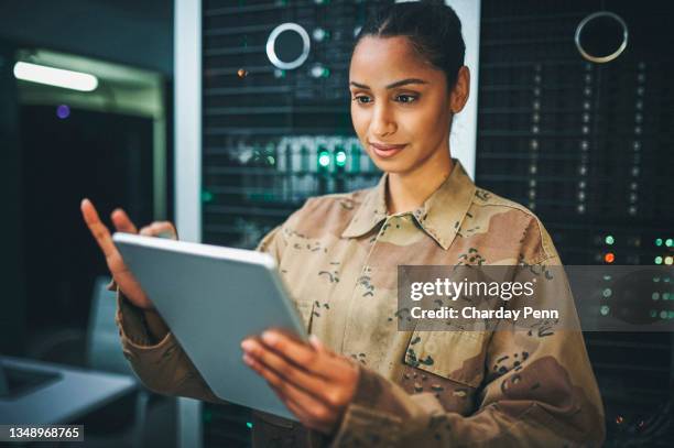 サーバールームに立っている若い女性兵士のショット - armed forces ストックフォトと画像