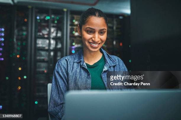 photo d’une technicienne informatique dans une salle de serveurs et utilisant un ordinateur portable - technicien informatique photos et images de collection